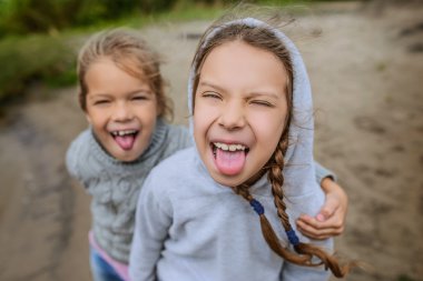 İki kız kardeş gösterir dil