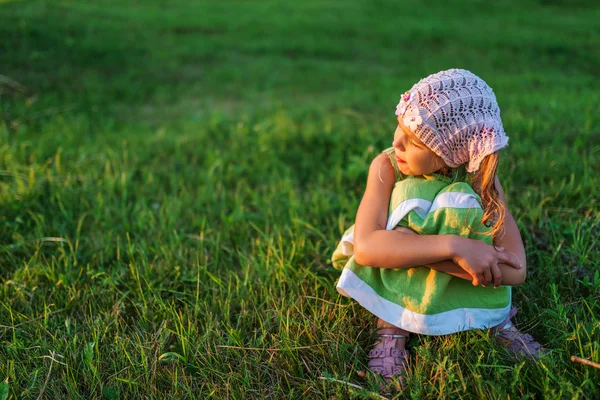 Trochę piękna dziewczyna siedzi na trawie — Zdjęcie stockowe