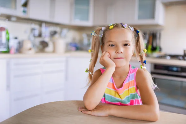 Kleines Mädchen sitzt am Tisch — Stockfoto