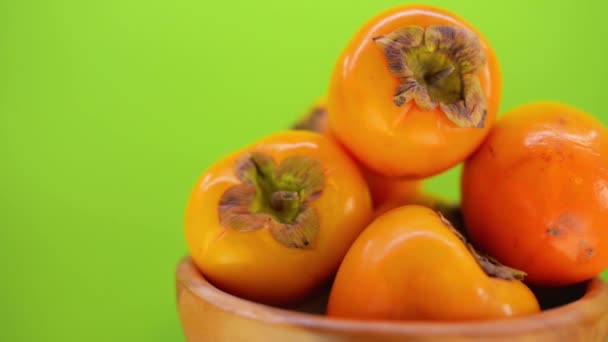 Beautiful ripe persimmon in wooden plate — Stock Video