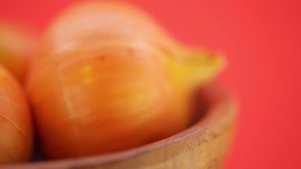 Oignons bruns dans une assiette en bois 