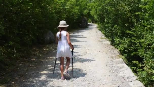 Маленькая девочка занимается скандинавской ходьбой — стоковое видео