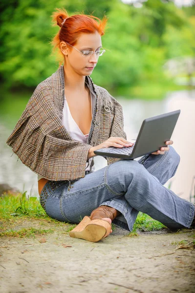 Meisje met laptop buiten — Stockfoto