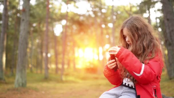 Hermosa niña sonriente con teléfono móvil — Vídeos de Stock