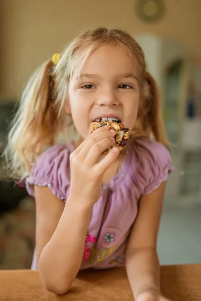 Маленькая красивая девочка ест вкусное печенье — стоковое фото