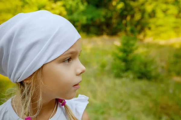 Маленькая спокойная девочка в белом шарфе в профиль — стоковое фото