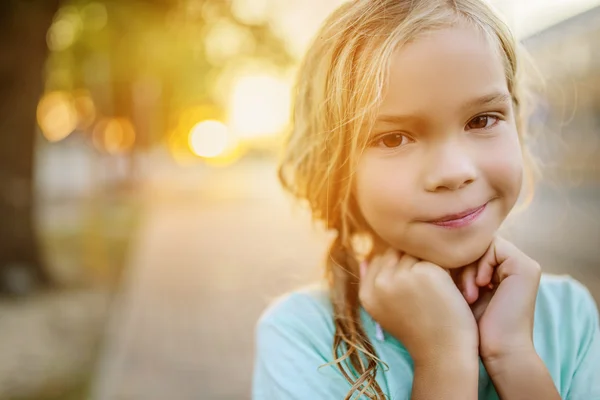 Little girl on background of sunset on street — Stock Photo, Image