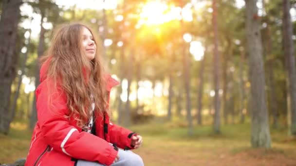 Niña sonriente con chaqueta roja en el parque de otoño — Vídeos de Stock