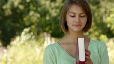 Genç kadın kırmızı kapaklı kitap okuma