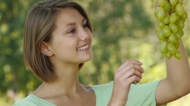 üzüm yiyen genç kadın gülüyor