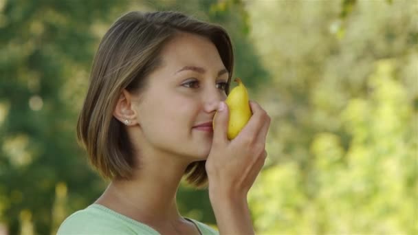 Woman close-up in blue shirt pear bites — Stock Video