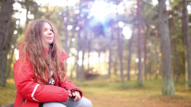 Niña sonriente con chaqueta roja en el parque de otoño — Vídeos de Stock