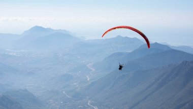 Türkiye 'nin Antalya ilinin Türk Rivierası' ndaki bir sahil beldesi olan Kemer yakınlarındaki dağların üzerinden uçan Paraglider