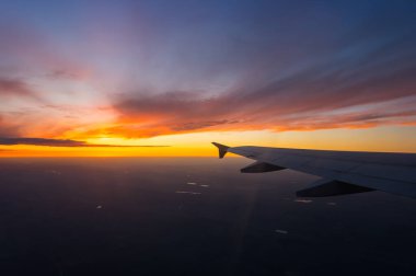 Uçak penceresinden gün batımının görüntüsü