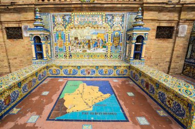 SEVILLE, SPAIN - 07 Nisan 2019: İspanya 'nın büyük bir turizm merkezi olan Seville' deki Plaza de Espana 'nın duvarları boyunca uzanan fayanslı taşra oyuğu