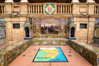 SEVILLE, SPAIN - 07 Nisan 2019: İspanya 'nın büyük bir turizm merkezi olan Seville' deki Plaza de Espana 'nın duvarları boyunca uzanan fayanslı taşra oyuğu
