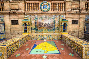 SEVILLE, SPAIN - 07 Nisan 2019: İspanya 'nın büyük bir turizm merkezi olan Seville' deki Plaza de Espana 'nın duvarları boyunca uzanan fayanslı taşra oyuğu