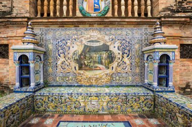 SEVILLE, SPAIN - 07 Nisan 2019: İspanya 'nın büyük bir turizm merkezi olan Seville' deki Plaza de Espana 'nın duvarları boyunca uzanan fayanslı taşra oyuğu