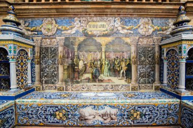 SEVILLE, SPAIN - 07 Nisan 2019: İspanya 'nın büyük bir turizm merkezi olan Seville' deki Plaza de Espana 'nın duvarları boyunca uzanan fayanslı taşra oyuğu