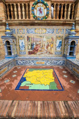 SEVILLE, SPAIN - 07 Nisan 2019: İspanya 'nın büyük bir turizm merkezi olan Seville' deki Plaza de Espana 'nın duvarları boyunca uzanan fayanslı taşra oyuğu