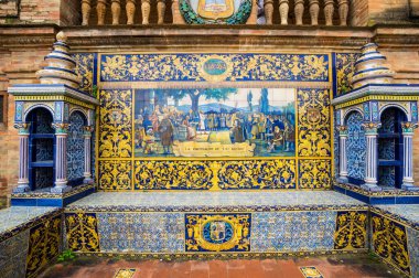 SEVILLE, SPAIN - 07 Nisan 2019: İspanya 'nın büyük bir turizm merkezi olan Seville' deki Plaza de Espana 'nın duvarları boyunca uzanan fayanslı taşra oyuğu