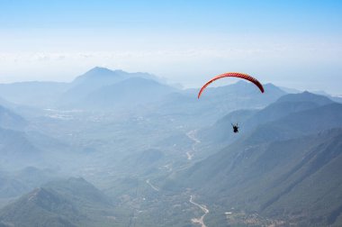 Türkiye 'nin Antalya ilinin Türk Rivierası' ndaki bir sahil beldesi olan Kemer yakınlarındaki dağların üzerinden uçan Paraglider