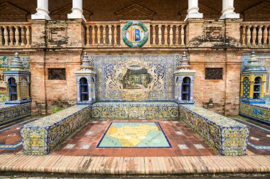 SEVILLE, SPAIN - 07 Nisan 2019: İspanya 'nın büyük bir turizm merkezi olan Seville' deki Plaza de Espana 'nın duvarları boyunca uzanan fayanslı taşra oyuğu