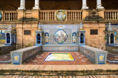 SEVILLE, SPAIN - 07 Nisan 2019: İspanya 'nın büyük bir turizm merkezi olan Seville' deki Plaza de Espana 'nın duvarları boyunca uzanan fayanslı taşra oyuğu