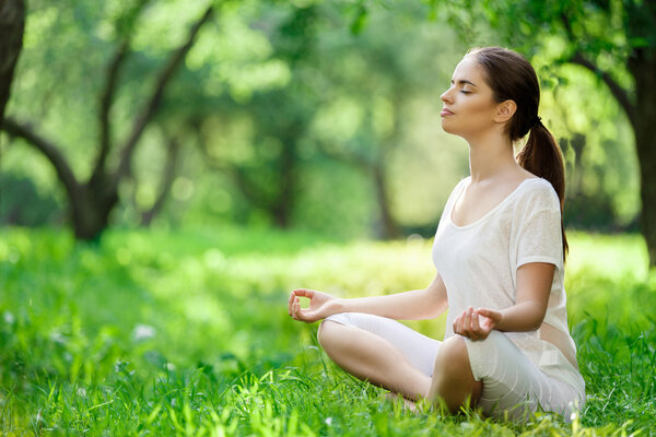 Молодая девушка в позе лотоса
