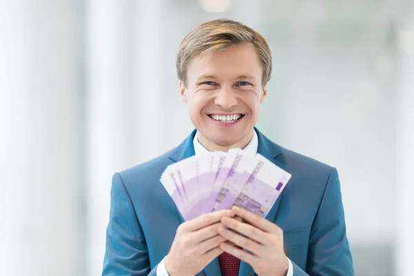 Uśmiechający się biznesmen gospodarstwa pieniądze — Zdjęcie stockowe