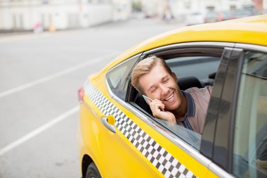 Genç adam telefonda konuşuyor.