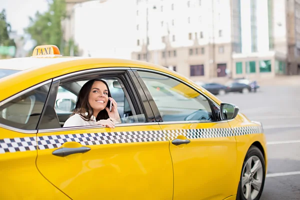 Mulher sorridente em um táxi — Fotografia de Stock