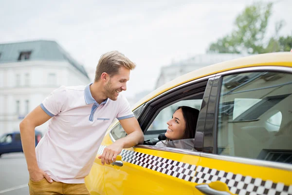 Молода пара в жовтому таксі — стокове фото