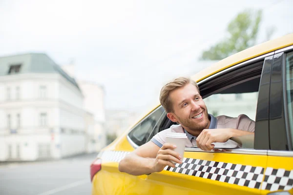 Lächelnder Mann im gelben Taxi — Stockfoto