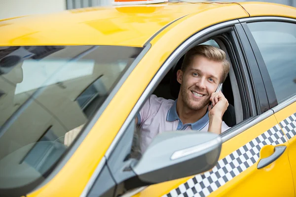 Homem sorridente em um táxi amarelo — Fotografia de Stock