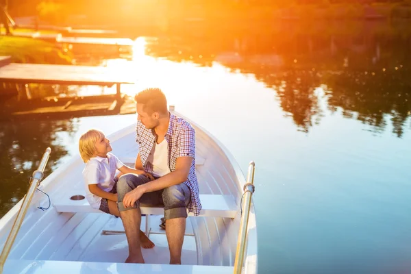Pappa och son i båt vid solnedgången — Stockfoto