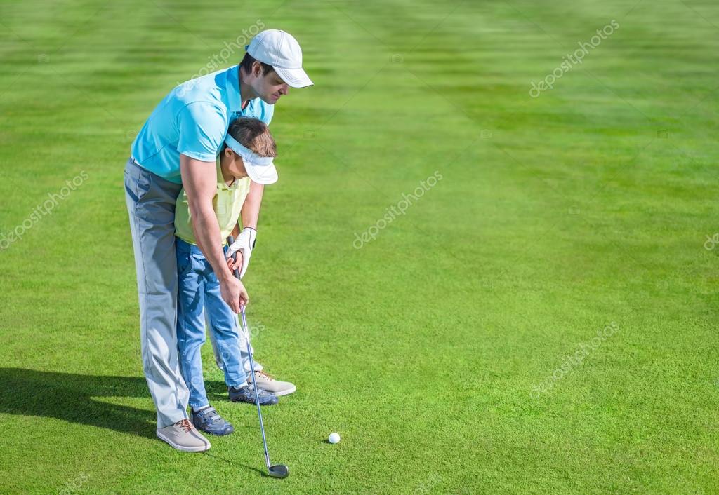 Dad and son playing golf Stock Photo by ©Deklofenak 112549814