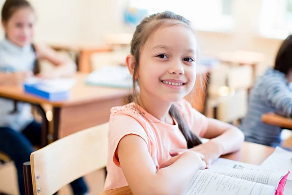 Schoolgirl in a classroom — Stock Photo, Image