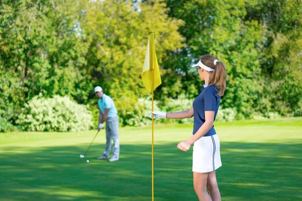 Pareja joven jugando al golf — Foto de Stock