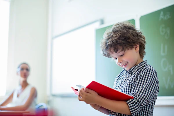 Leerling met boek in klas — Stockfoto