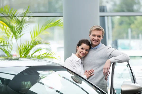 Coppia sorridente con auto — Foto Stock