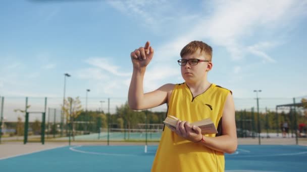 Jeune Garçon Avec Livre Calcul Sur Terrain Basket — Video