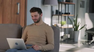 Happy man video calling with friends at home