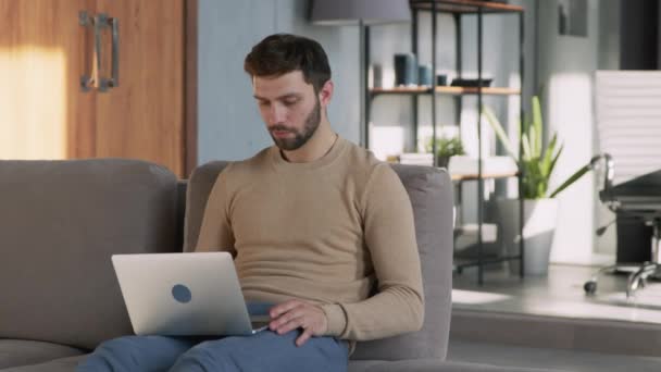 Young man experiencing stress at work with laptop at home — Stok video