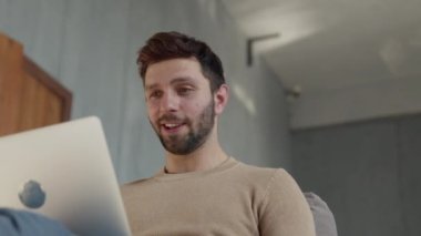 Videoyla iletişim kuran gülümseyen genç adam.
