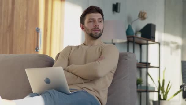 Молодой парень сидит дома на работе в ноутбуке — стоковое видео