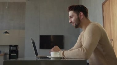Genç bir adam arkadaşlarıyla canlı yayında konuşuyor, laptopta konuşuyor.