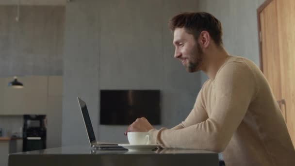 Un giovane uomo che parla in diretta video con gli amici, parlando sul computer portatile — Video Stock