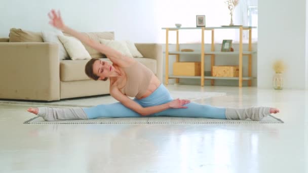 Ragazza attraente in abbigliamento sportivo facendo posizione yoga in soggiorno — Video Stock