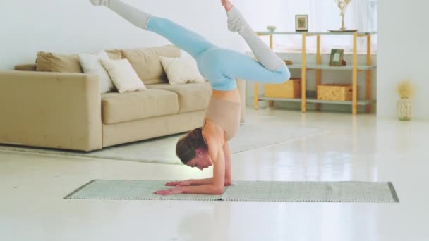 Młody jogista w odzieży sportowej medytujący w domu rano. Atrakcyjna kobieta uprawiająca jogę — Wideo stockowe